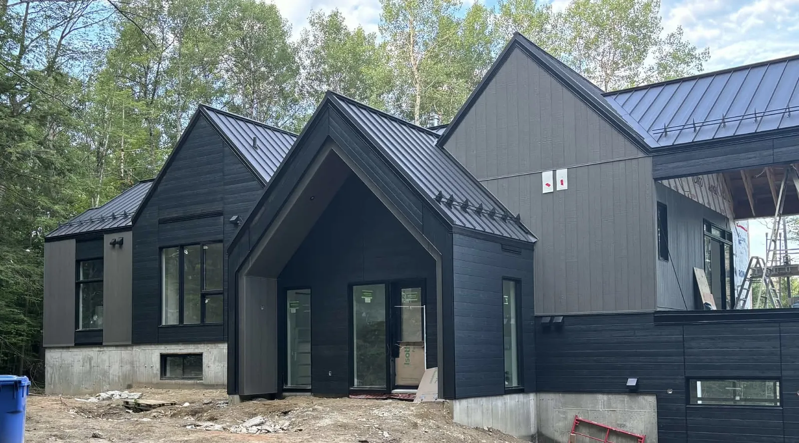 Side view of a modern Cumberland, Ottawa home with black CanExel V-Joint siding and steep metal roof