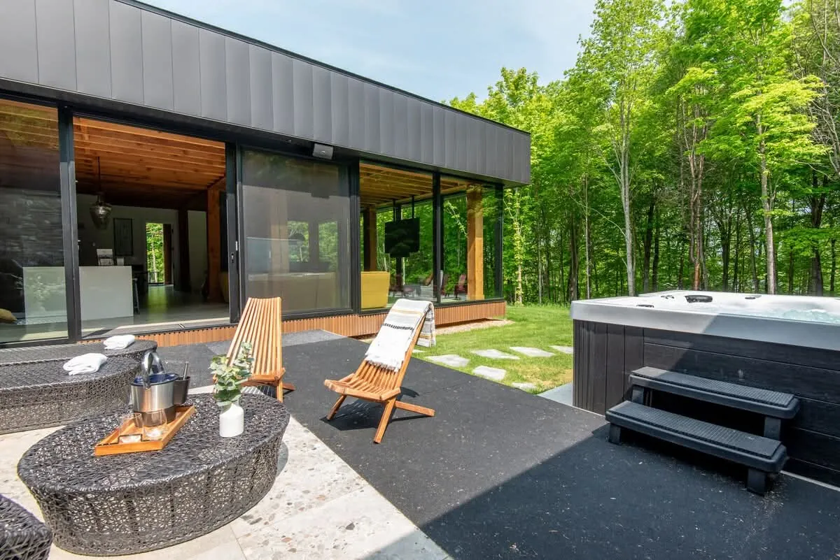 Rear of a Navan home showing Fiberwood fluted siding, stone and wide MAC metal fascia across the roofline